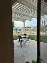 Covered patio w a table/chairs as well as a bench . More soon to come
