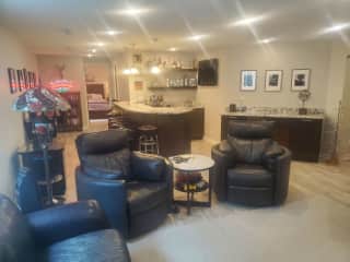 Basement bar and lounge with 75 inch Flat screen cable TV fridge for drinks, dishwasher and sink.