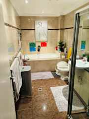 The bathroom with bath and shower.
