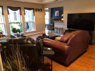 View of large TV in the living room and view into the den.