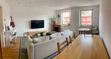 A large dining area behind the TV and sofa.