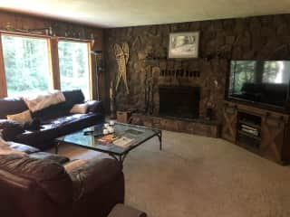 Family Room off Kitchen with Propane starter wood burning fireplace and large TV.