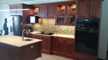 Cooktop, ovens, microwave, refrigerator, vegetable sink in center island.