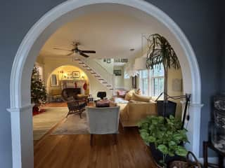 Living room with a upright piano, and there is a tv. room not shown with another couch and baby grand piano.