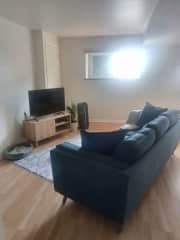 Sunny living room with very comfy couch, and a TV for streaming. High speed wifi throughout the apartment.