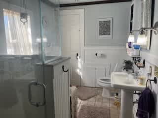 Upstairs bathroom with glassed shower and laundry