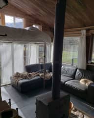 The living room features a wood burner and a loft bed.