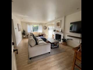 Open, bright living room with wood burning fireplace.