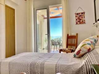Guest bedroom with doors to a lovely balcony with open sea views