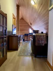 Looking at the loft from the area of the guest bedroom and bathroom doors. The office desk, chair, and printer are located at the loft rail overlooking the living room.