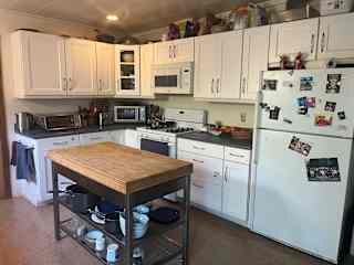 Open kitchen with gas (propane) stove and oven, kitchen island, and all the appliances: electric kettle, air fryer, microwave, 4-slot toaster, Vitamix, and more.