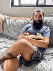 Baby the cat melting into Dino's arms