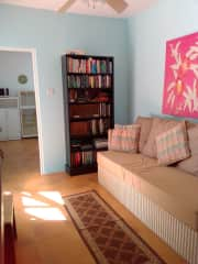 TV room/living room.  looking through the door into the kitchen you can see the microwave stand with storage for appliances and the fridge.