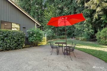 East side of house with patio in fenced backyard.