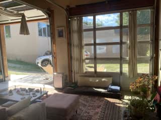 View from bedroom door of living room area. All garage doors fully open, as desired, for indoor/outdoor living!