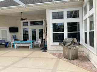 Screened patio and pool with a dining area and gas grill.