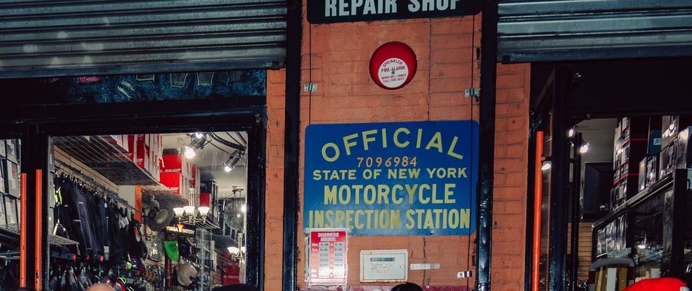 Official New York State Motorcycle Inspection Station sign above the Cycle Therapy NYC storefront entrance