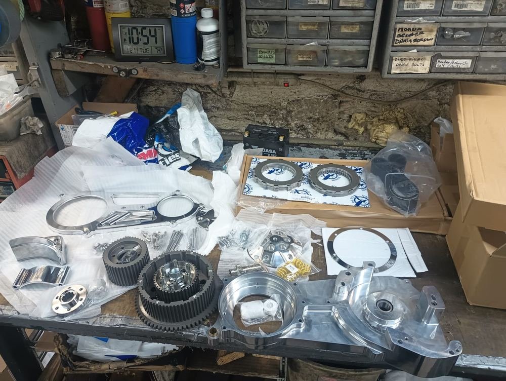 Custom billet motorcycle engine cases, clutch packs, and performance parts laid out on a workbench at Cycle Therapy NYC