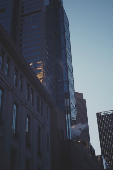A view of buildings with smoke coming out of vents