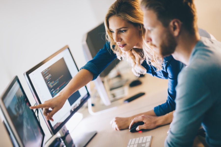 Woman showing a NEXTGEN code company developer a certain UI issue on a website.