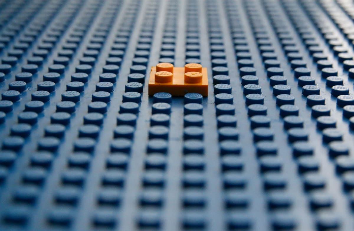 A Lego brick stacked on a larger Lego board