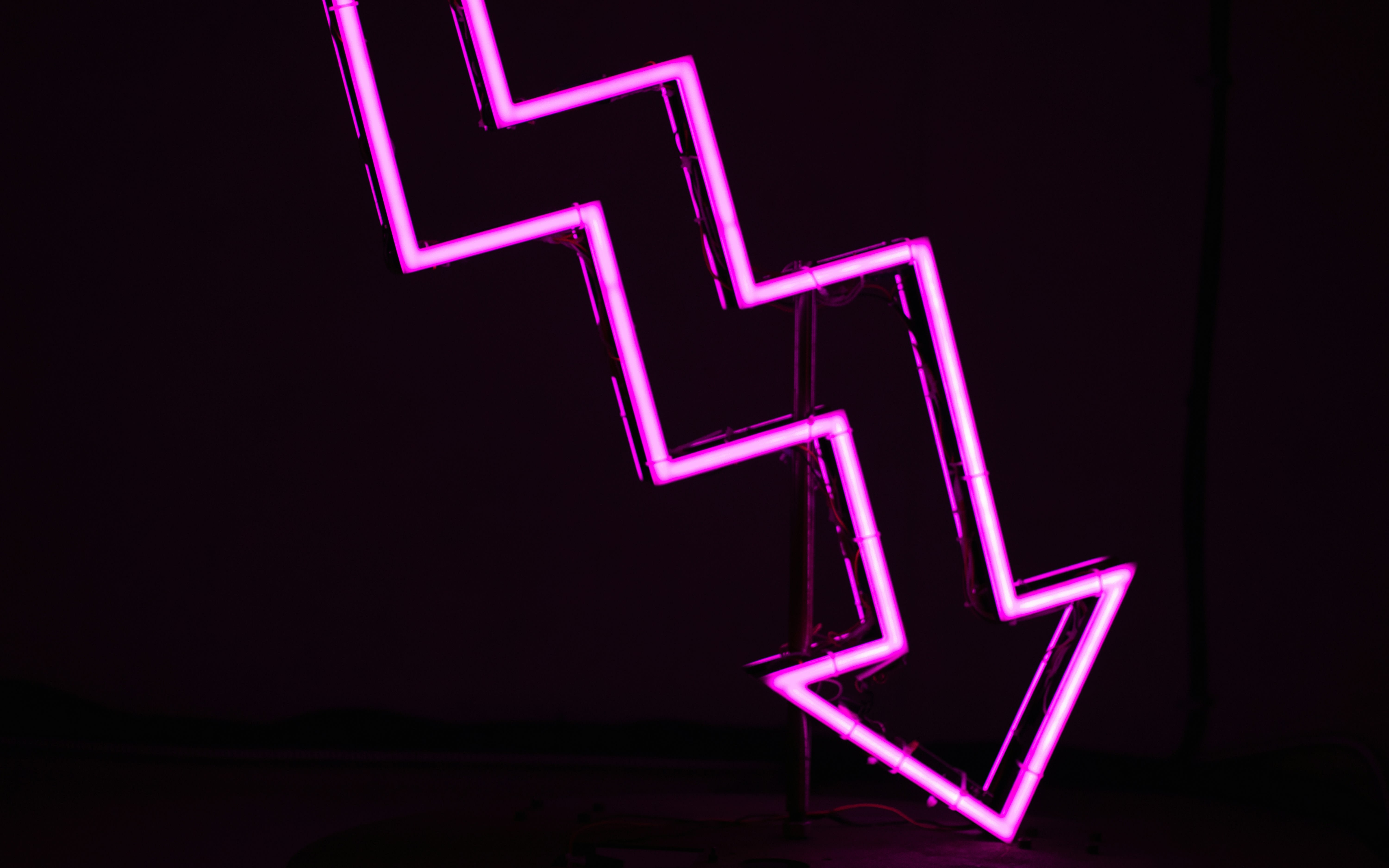 A neon pink jagged line pointing downwards