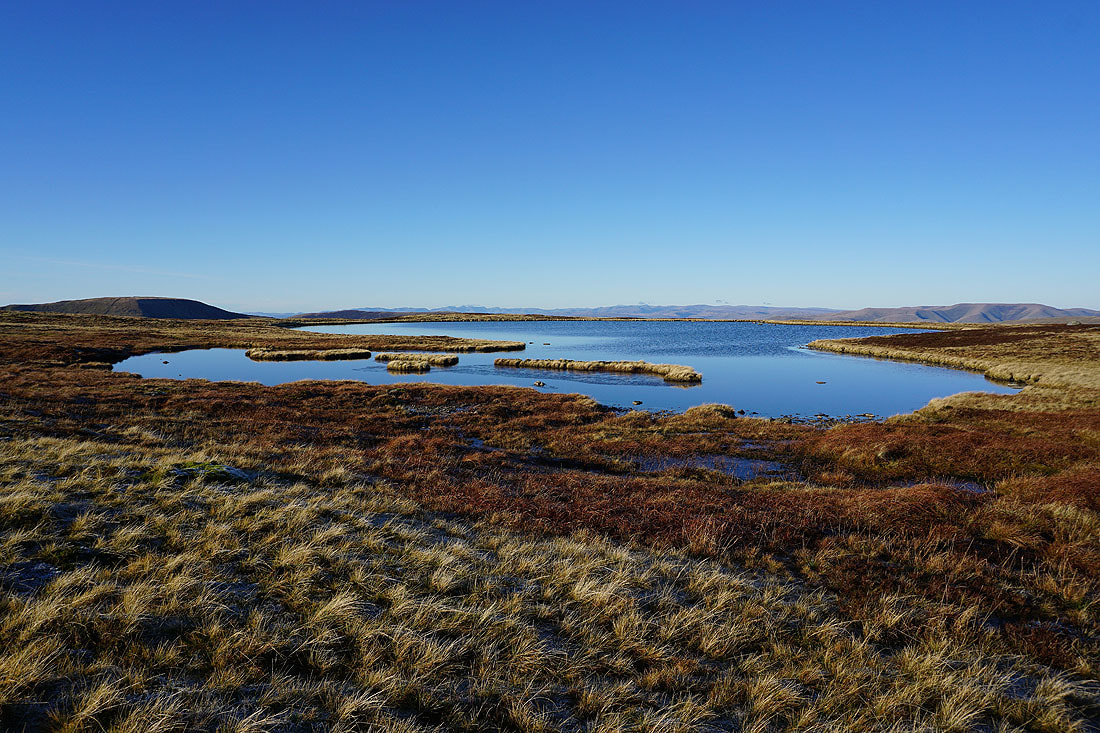 Open moorland and water beneath a clear sky