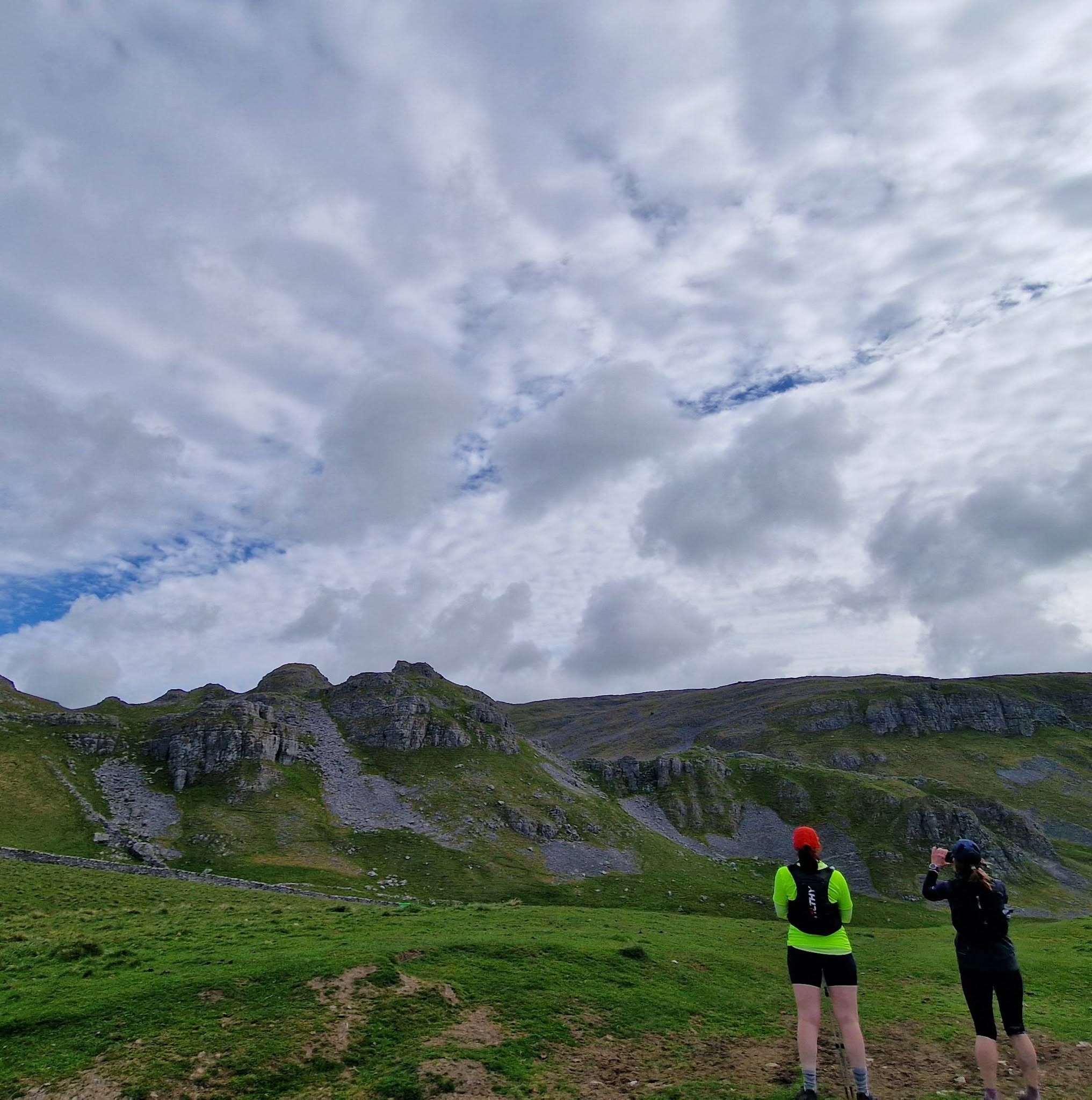 Runners passing below a limestone escarpment