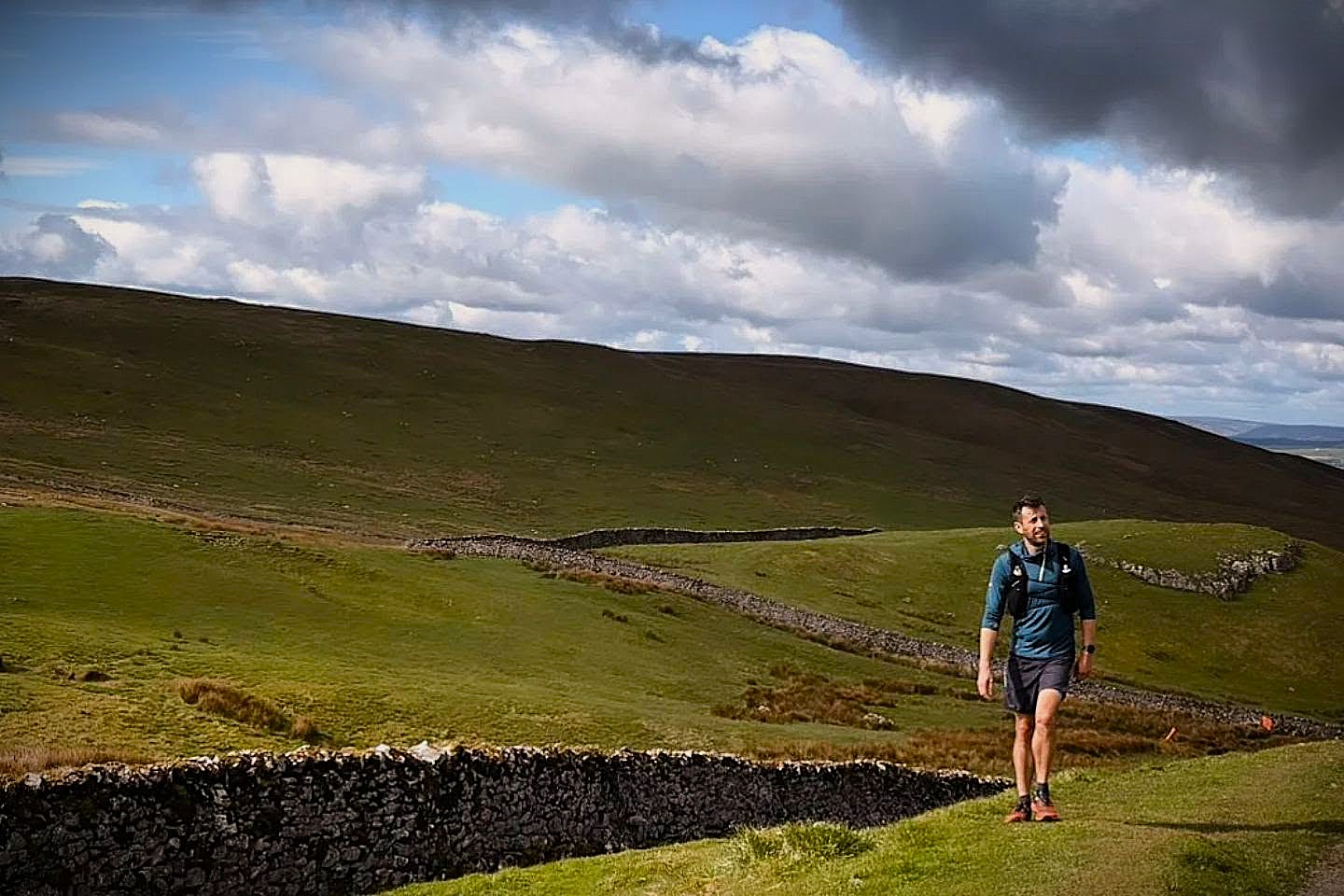 Hef running beside drystone walls under a big Dales sky