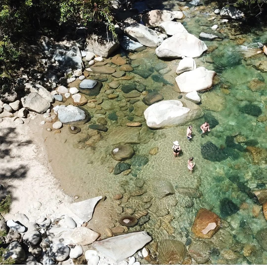 Vista aérea de amigos en un charco de agua cristalina en el río cerca de Guatapé