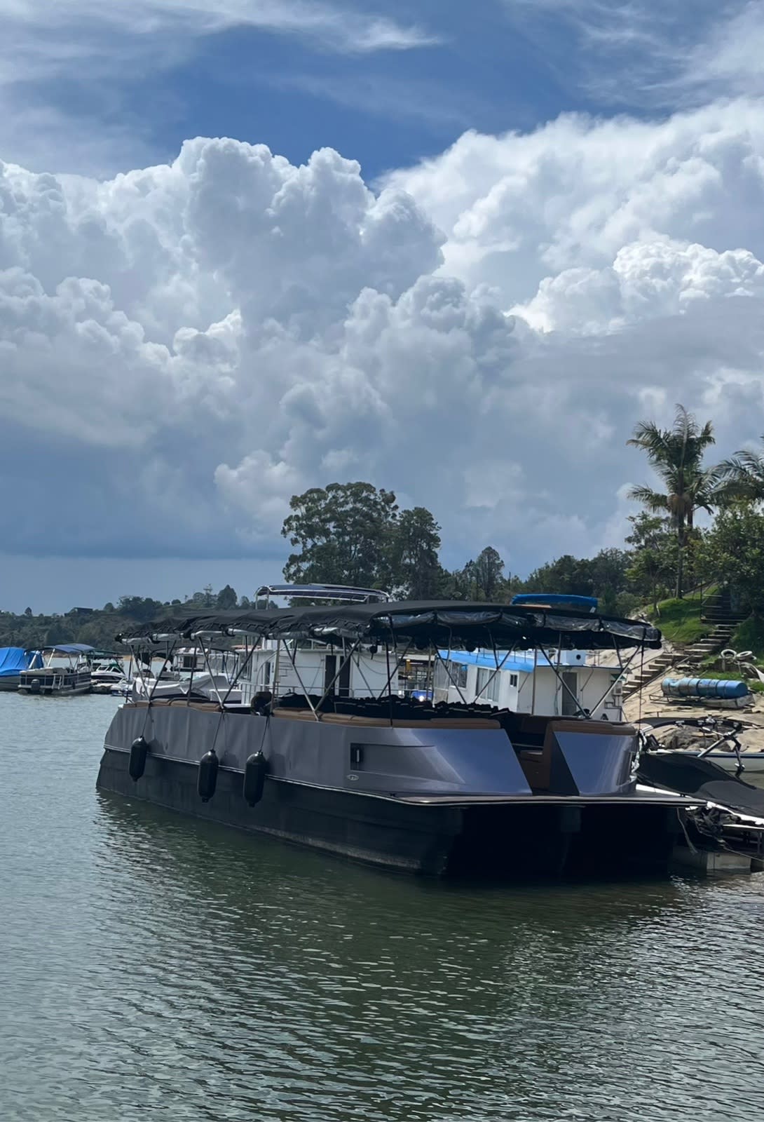 El planchón para 50 personas en el embalse de Guatapé, bajo grandes nubes blancas