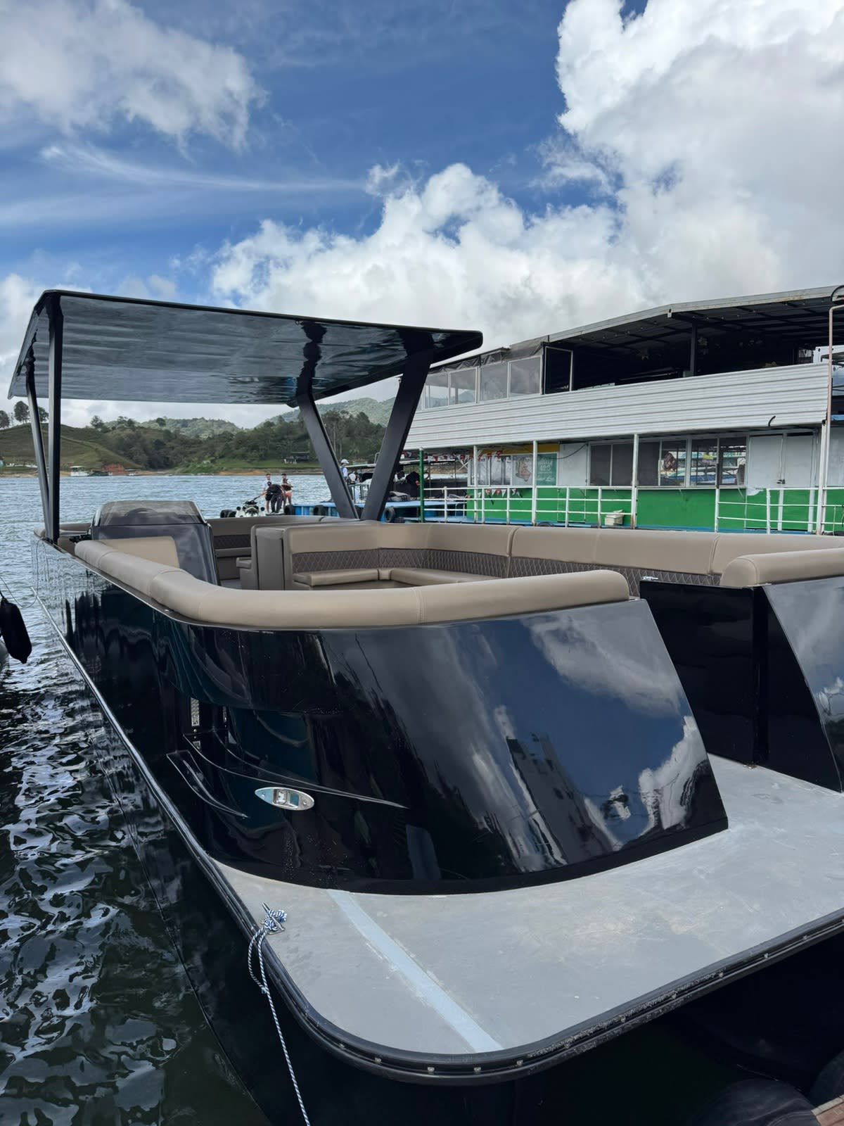 El planchón luxury negro en el muelle de Guatapé, con su techo rígido