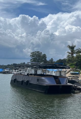 El planchón para 50 personas en el embalse de Guatapé, bajo grandes nubes blancas
