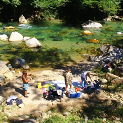 Familia disfrutando un picnic sobre las piedras junto al río