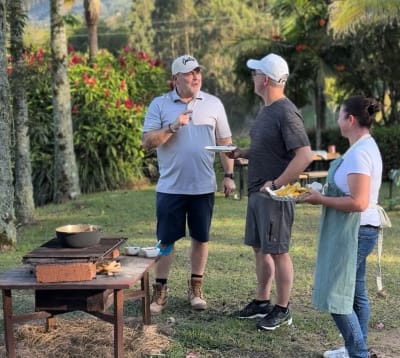 Invitados aprendiendo a hacer empanadas al aire libre en una finca cerca de Guatapé