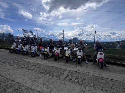 Group lined up on electric scooters at a viewpoint over Guatapé