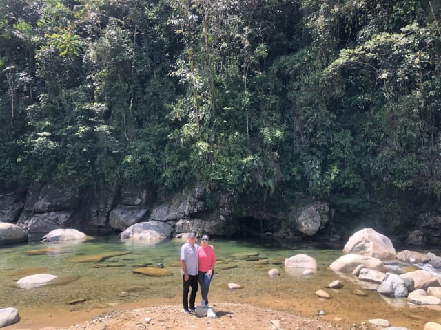Pareja en la playa del río rodeada de bosque