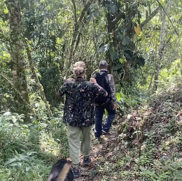 Guía local de aves llevando a visitantes por un sendero del bosque en Guatapé