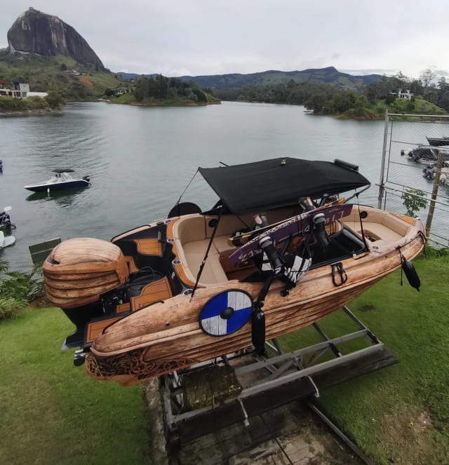 Lancha de wakeboard en la orilla con su torre y tablas