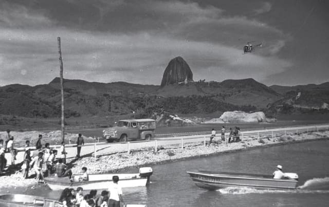 Foto antigua de la Piedra del Peñol y lanchas a orillas del embalse
