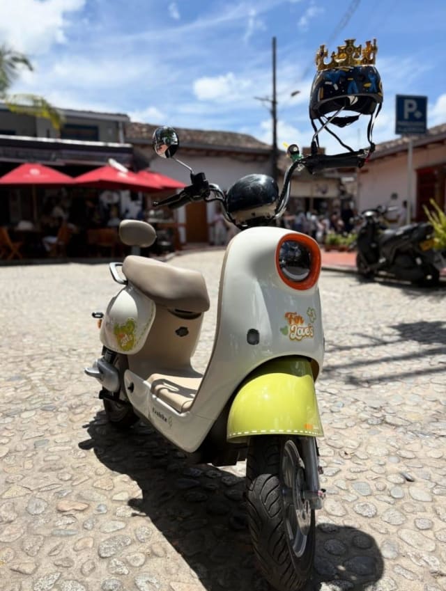 Cream and yellow electric scooter on the cobbled square of Guatapé