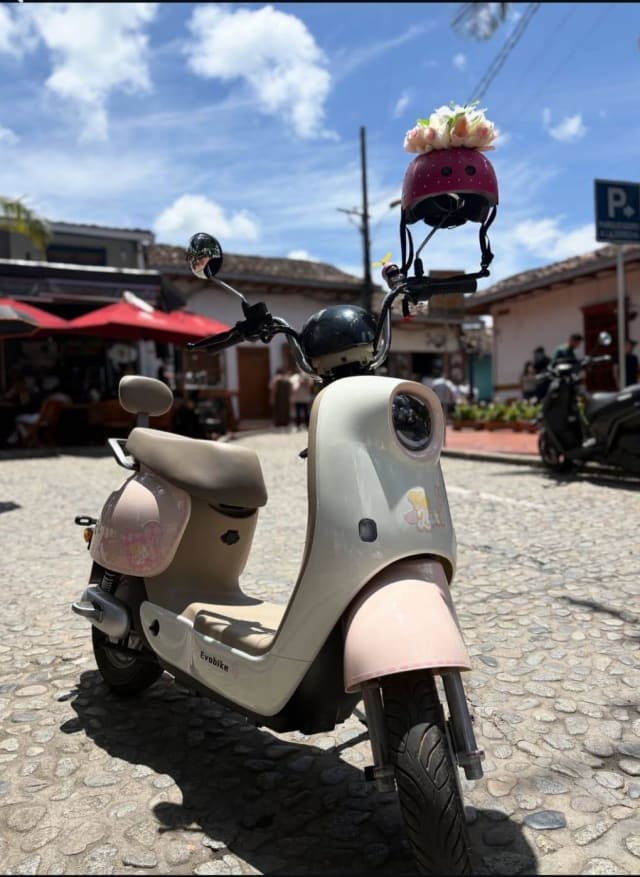 Pastel pink electric scooter parked in Guatapé's main square