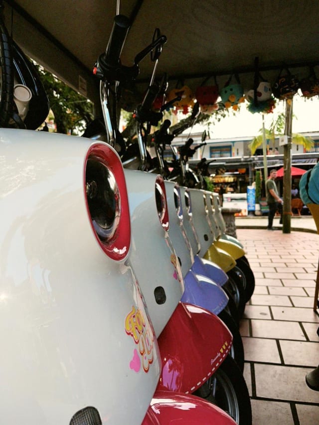 Row of colourful electric scooters ready for the town tour