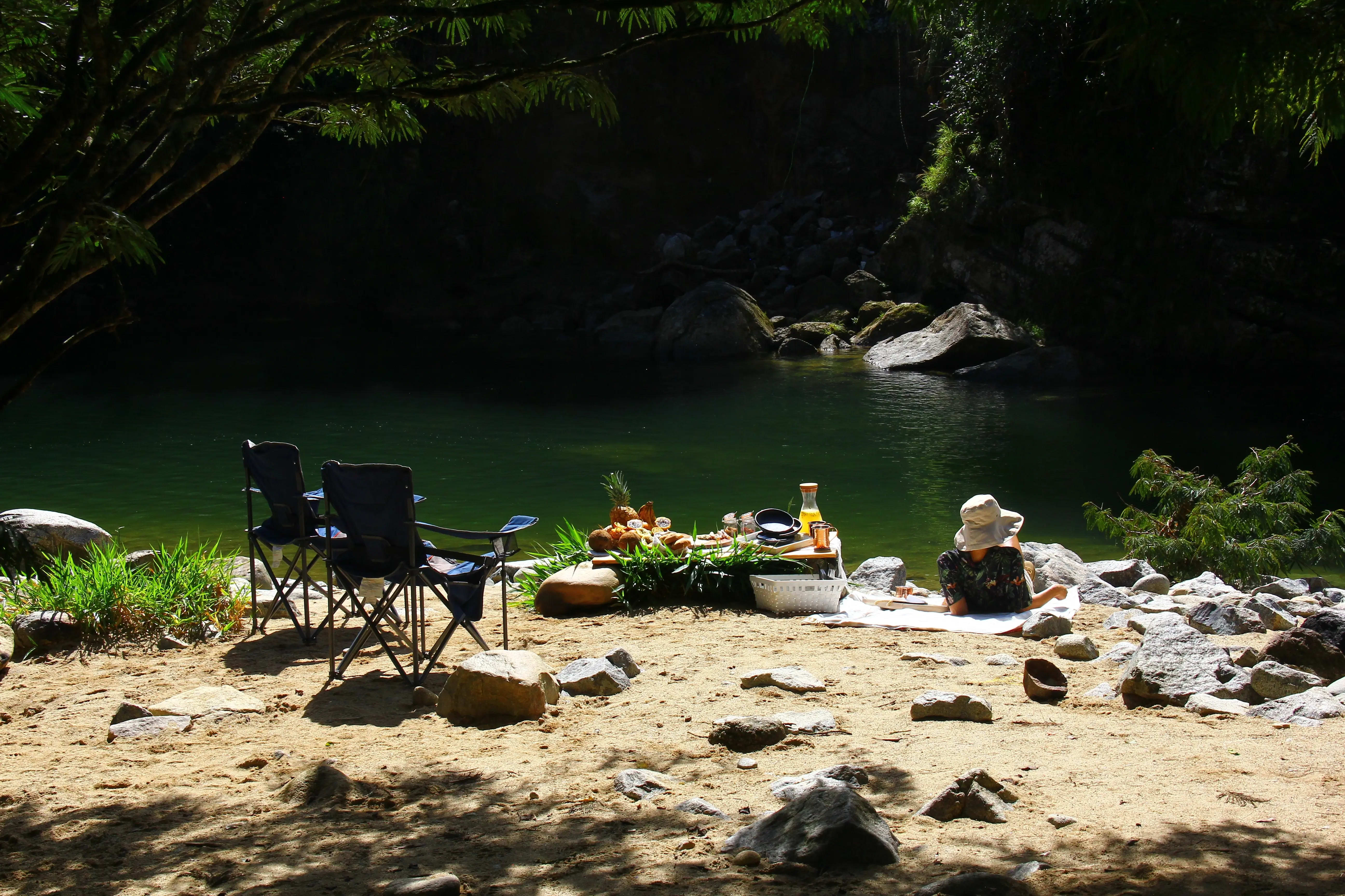 Picnic montado en la playa del río, con sillas junto al agua