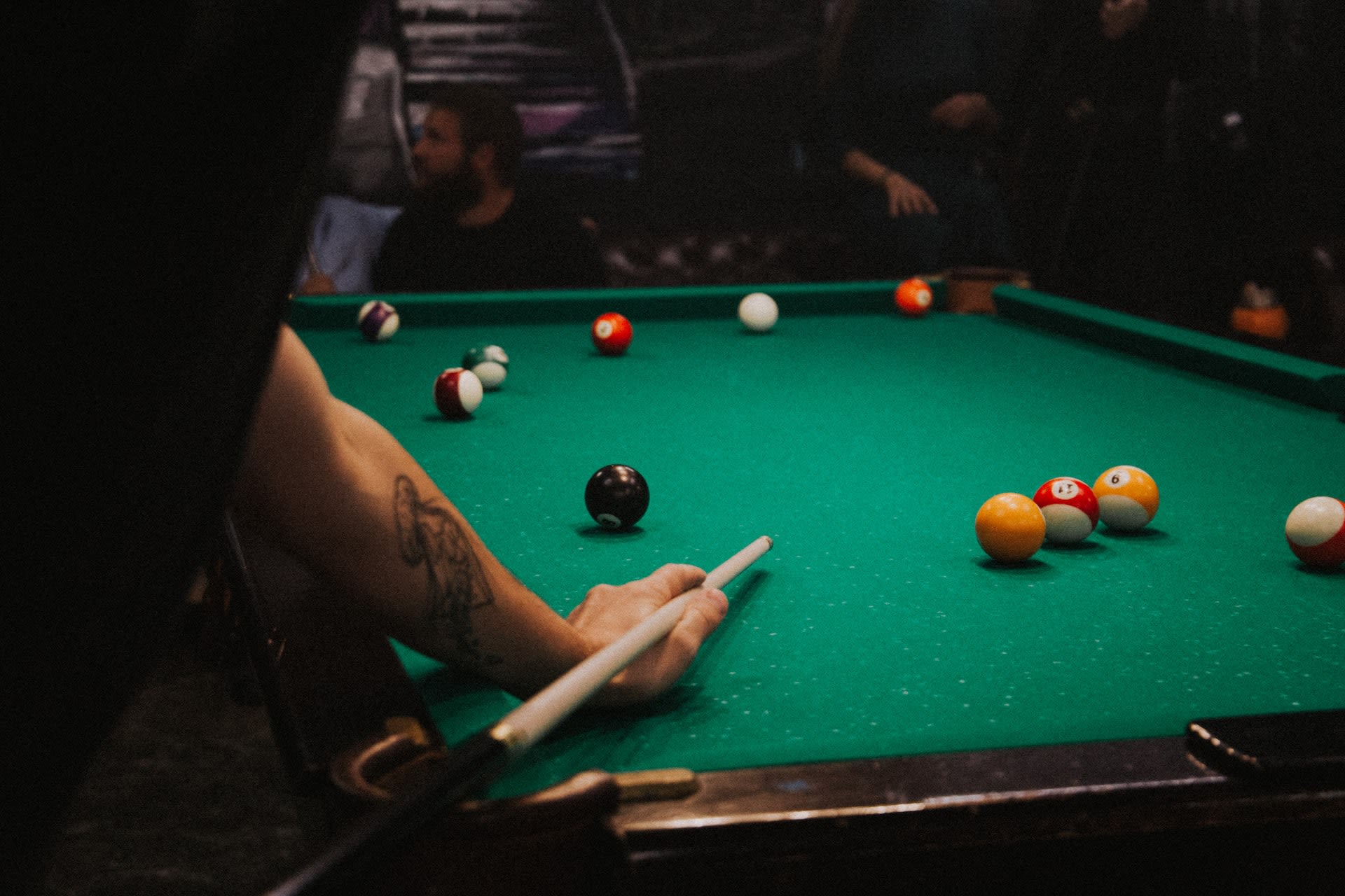 Men playing pool with second hand pool table set