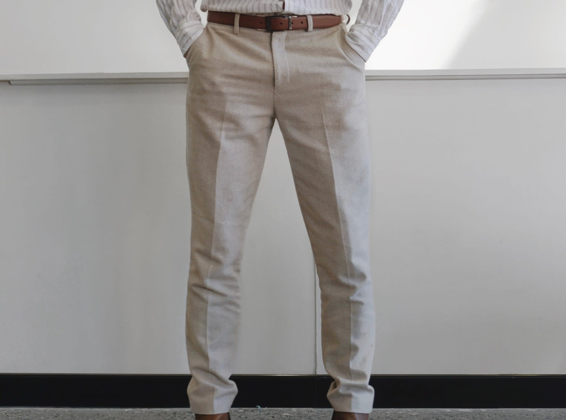 Groom wearing beige second-hand suit trousers