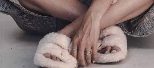 Close up of woman's feet wearing fluffy second-hand slippers