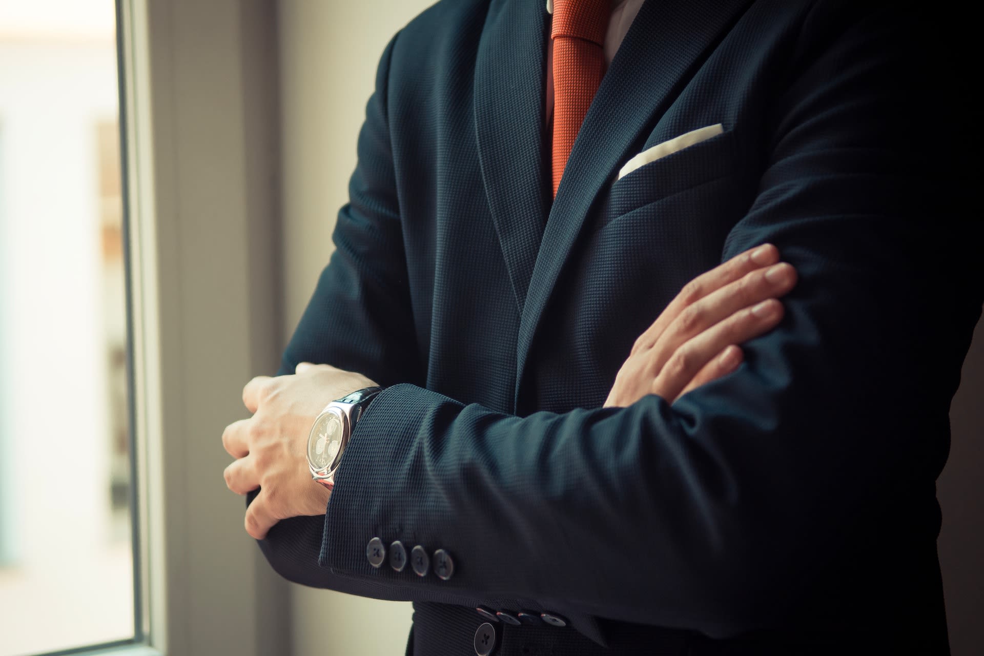 Man wearing a blue blazer with orange tie