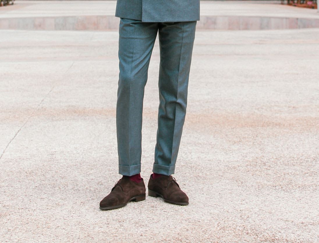 Man wearing grey suit trousers and brown shoes