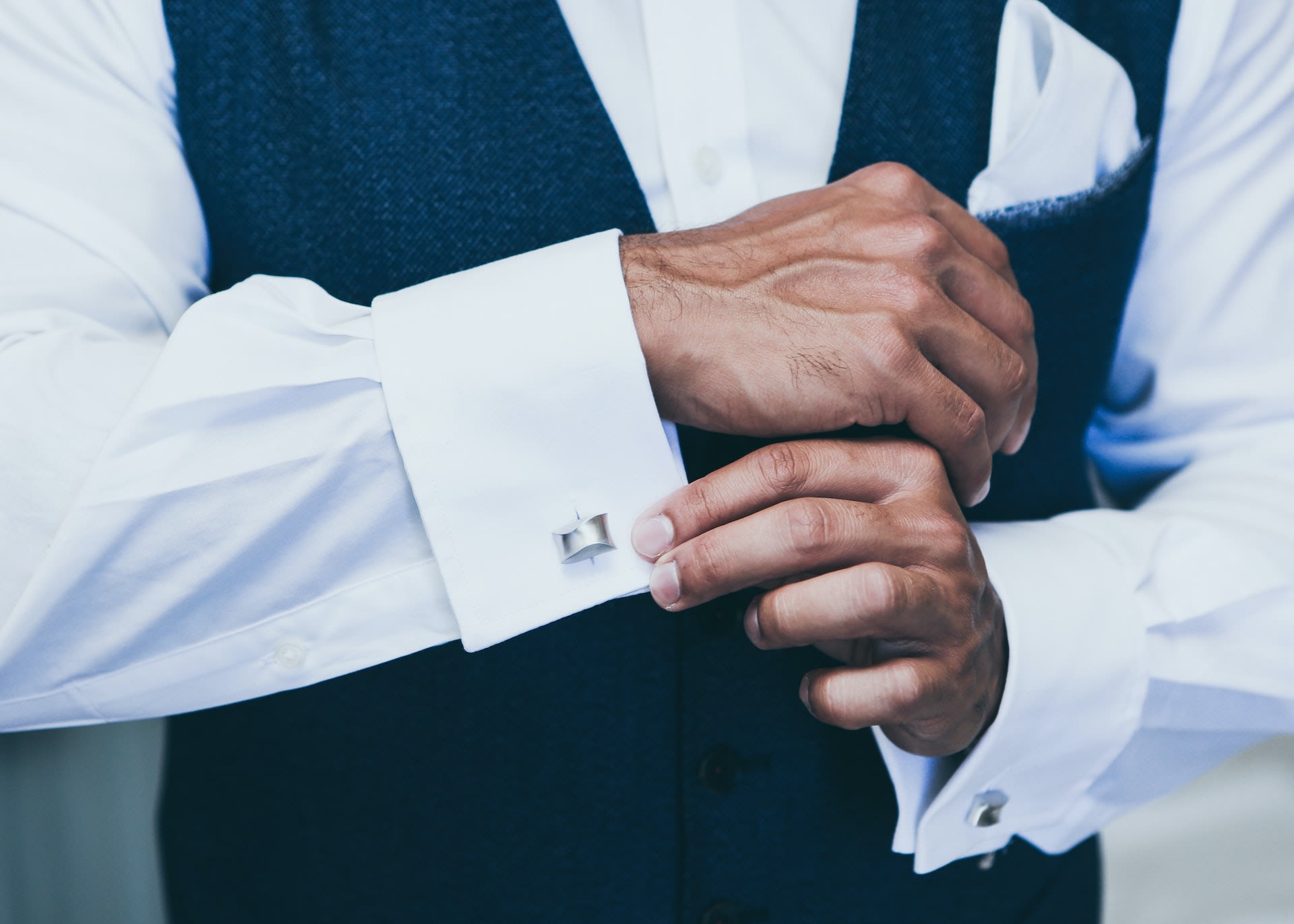 Man adjusting silver cufflinks